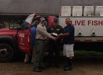 Foundation hands a check to WVDNR biologists at a fish hatchery truck — minnow funding for state waters.